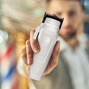 Saber 2 Professional Hair Clipper with EON Digital Brushless Motor held by man out of focus.