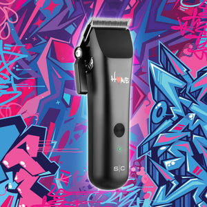 Homie nano hair clipper with a silver blade and white 'Homie' branding, centered against a vibrant, colorful graffiti background. Side view of click lever