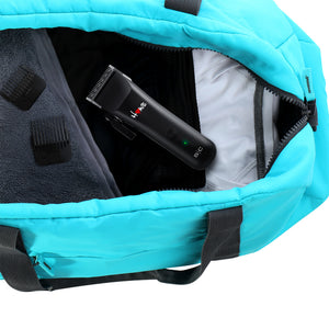 A turquoise blue backpack shown open, revealing a homie nano hair clipper inside. The bag has black handles, a black interior lining, and a light gray inner pocket visible on the right side. Showing travel size friendly or on the go.