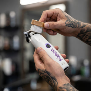 Reign trimmer with EON Digital Brushless Motor viewed in barber hand cleaning hair off trimmer