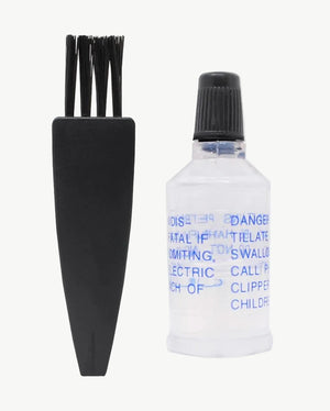 Maintenance Oil and Cleaning Brush Kit, black cleaning brush next to a clear bottle of clipper oil