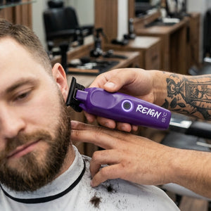 Reign trimmer with EON Digital Brushless Motor viewed in barber hands cutting customer hair
