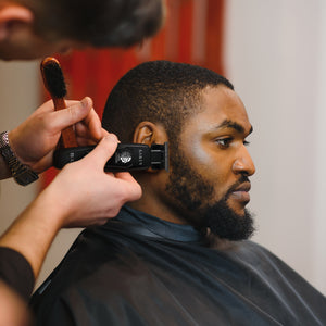 Black Saber Trimmer with Digital Brushless Motor in barber's hand cutting hair