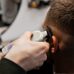 Reign trimmer with EON Digital Brushless Motor viewed in barber hands cutting customer hair