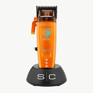 Orange and black Saber II clipper standing on a black charging dock against a white background.