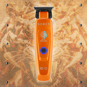 An orange pet clipper with a black guard head and a blue digital brushless button, centered on a textured brown and gold background with cat whiskers.
