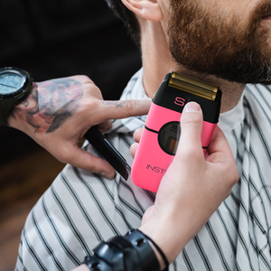 Instinct Metal Professional Double Foil Shaver Person using a pink electric shaver on another person's beard